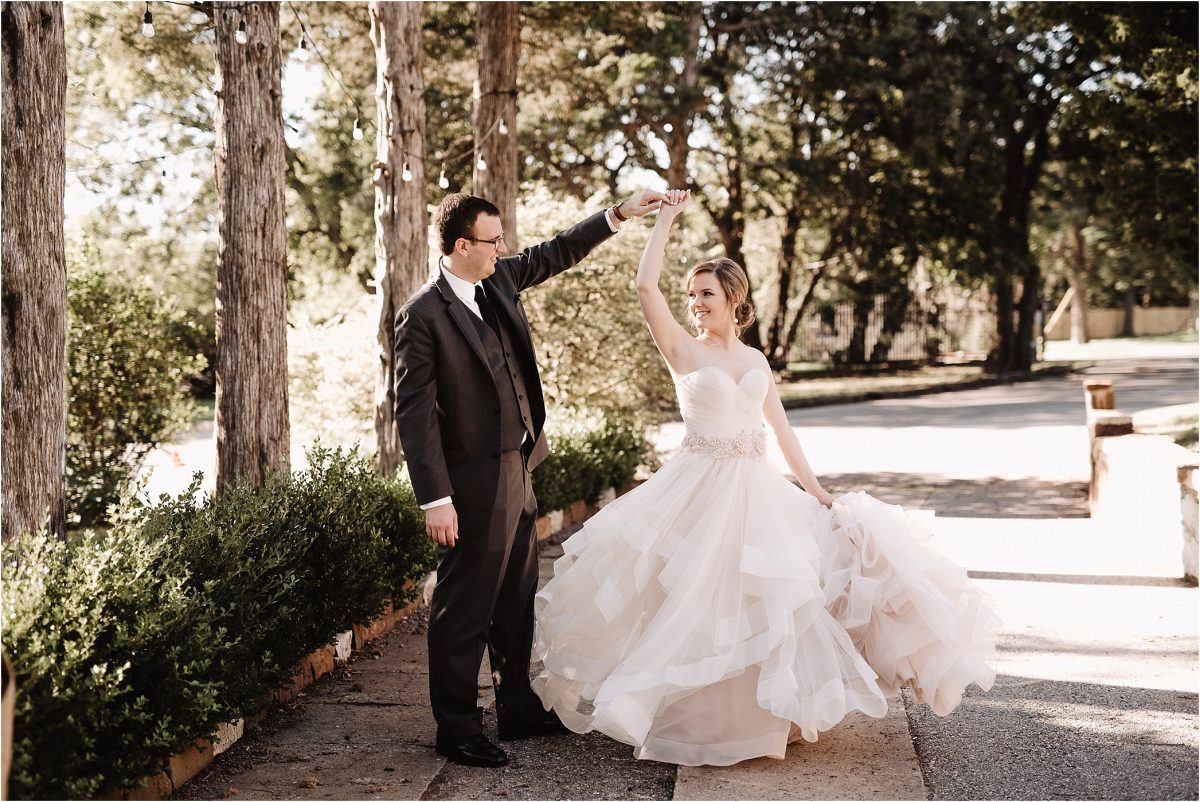 Groom spins bride in outdoor setting
